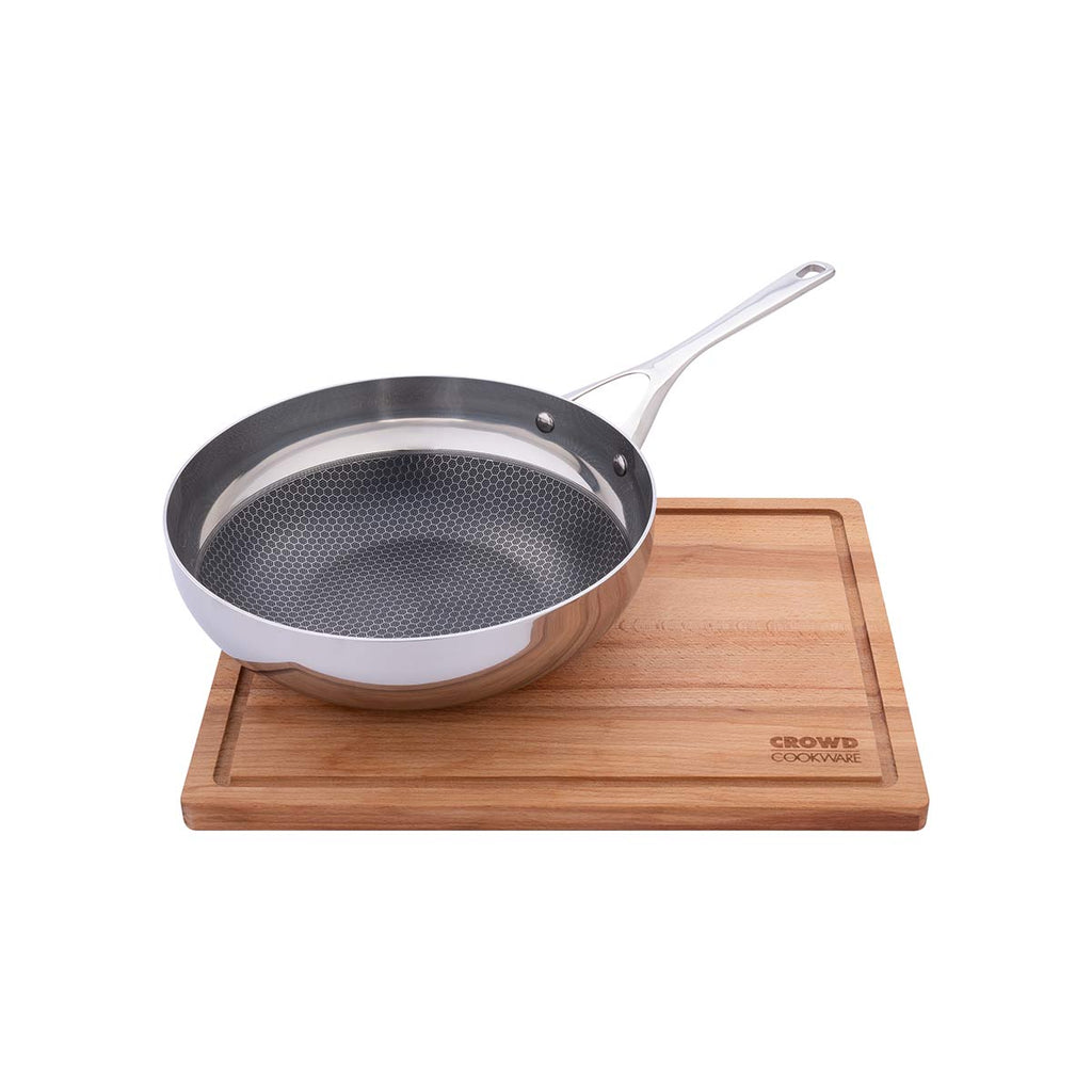 Beech wood rectangular cutting board 40x30 cm with integrated juice groove, Blackbeard frying pan on top, and Crowd Cookware logo, side view