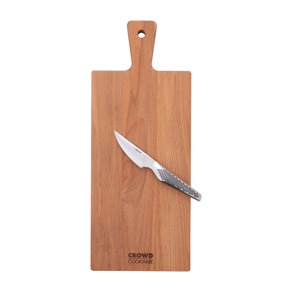Rectangular cutting board 50x20 cm with handle made of beech wood with crowd cookware logo with paring knife on top lifestyle image