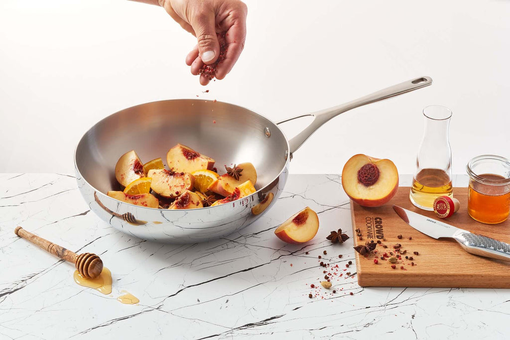 Titanium wok 28 cm in lifesyle setting with pineapple and kitchen knives side with cutting board